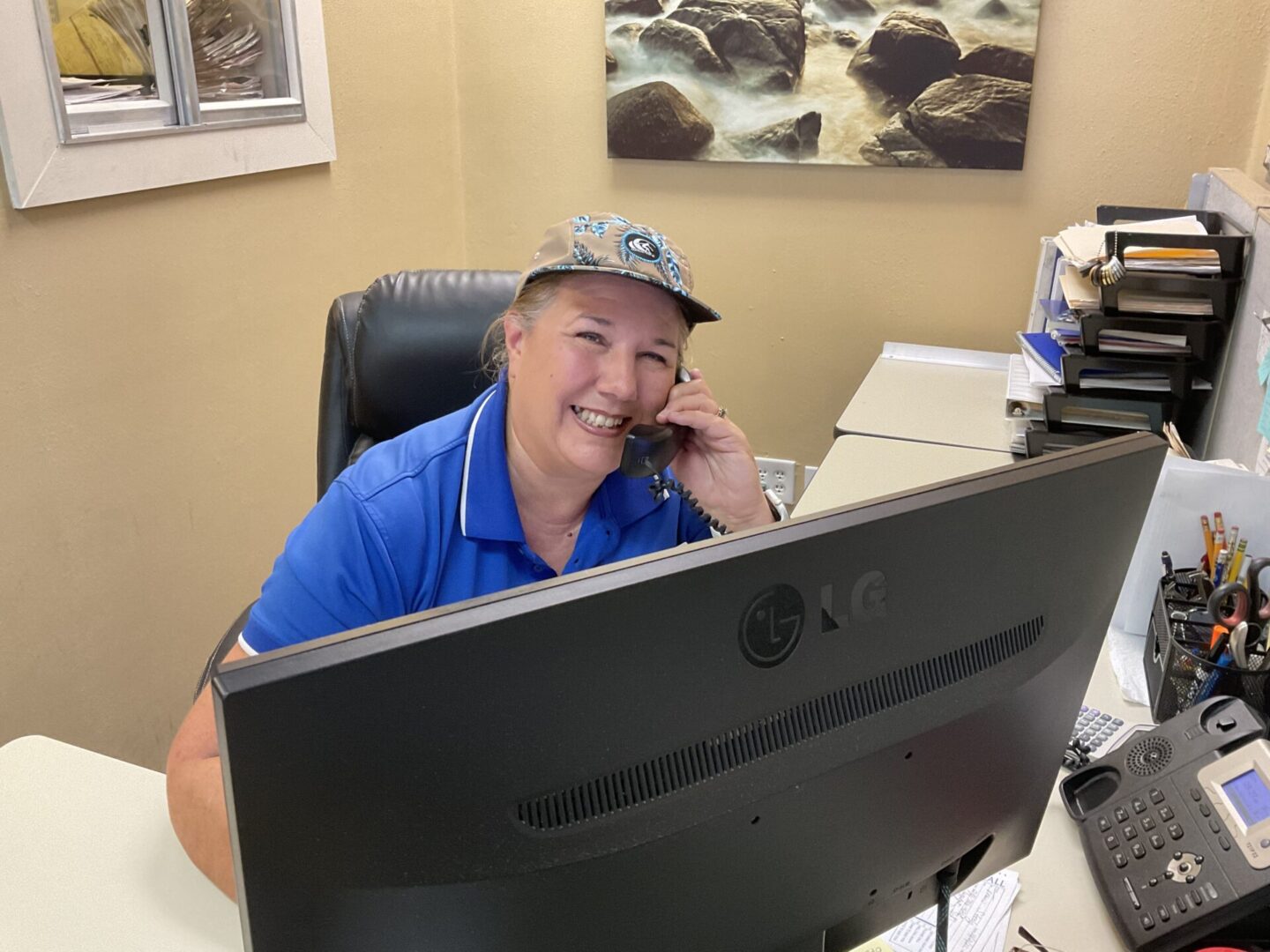 A man sitting at his desk talking on the phone.