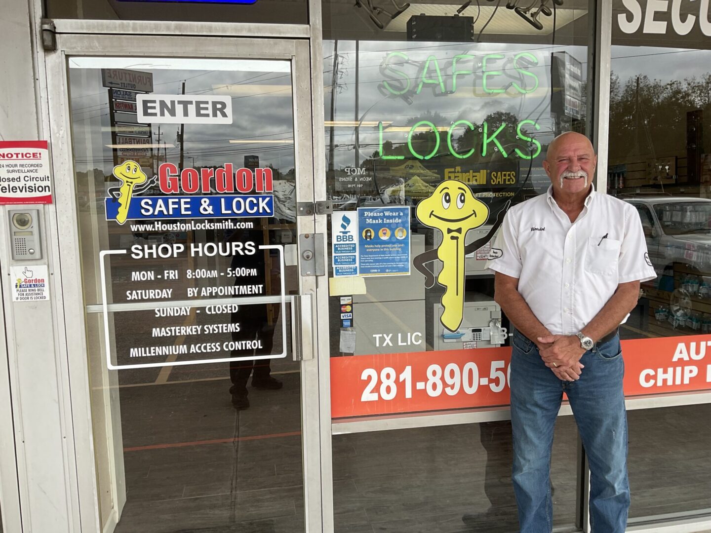 A man standing in front of a store window.